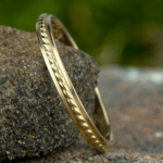 The Stylist Stackable Band in 14K Yellow Gold, 2MM Metal: 14K Yellow Gold Width: 2mm Size: 7 High polished band with a rope patterned center